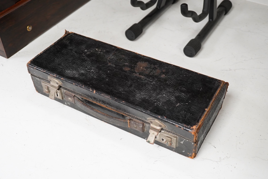 An early 20th century wooden Boosey and Hawkes clarinet in a fitted leather case